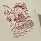 Back of the ivory Rival Bros Lakeside FREEZO Tee, a red illustration of a smiling fisherman casting from the shore beside a FREEZO cooler